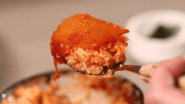 Rice mixed with kimchi stew broth on spoon