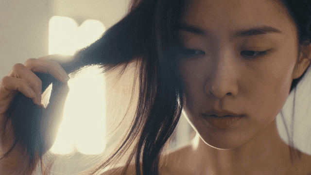 Young woman gently touching her hair