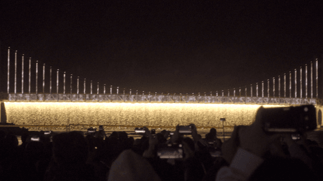 밤에 조명이 켜진 다리와 군중