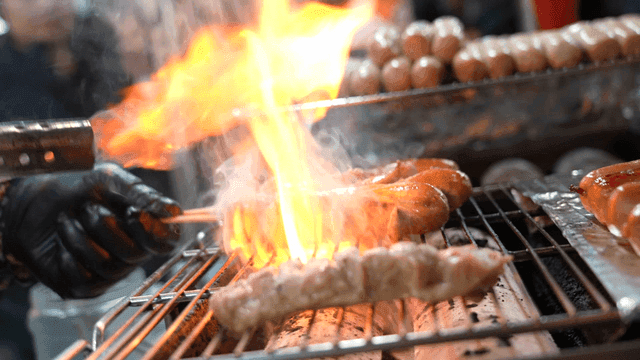 Grilling sausages over an open flame