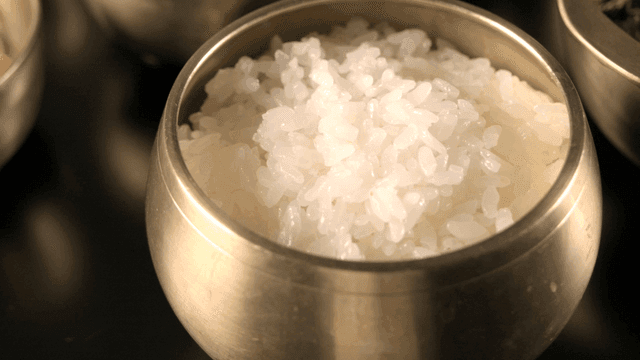 Steamed rice in a traditional brass bowl
