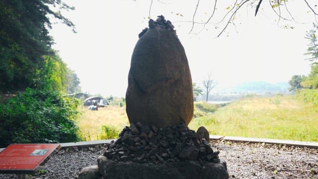 돌탑을 둘러싸고있는 무성한 나무와 녹지