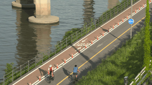 People riding bicycles along riverside path