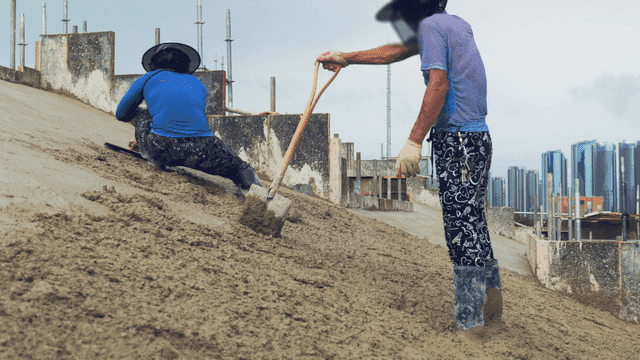 Workers smoothing concrete on a slope