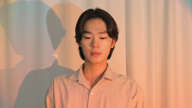 다채로운 조명 속에서 울 것 같은 남자