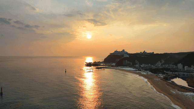 Sunset over a serene beach and coastal town