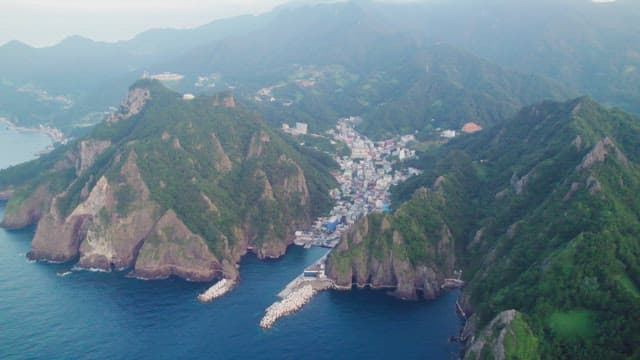 산 사이에 자리 잡은 해안 마을