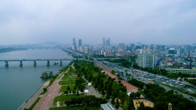 Cars Rushing in a Busy City under a Cloudy Sky