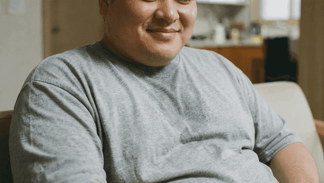 Fat man sitting comfortably on sofa