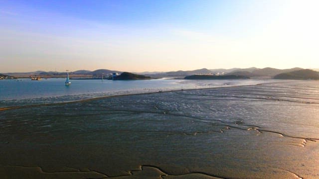 Road on a tidal flat revealed by low tide at sunrise