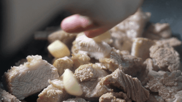 Chunks of meat being cooked with garlic