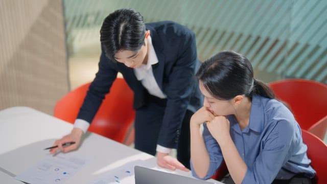 Two colleagues discussing documents