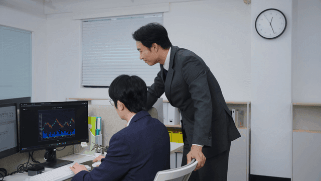 화면의 데이터를 논의하는 두 비즈니스맨