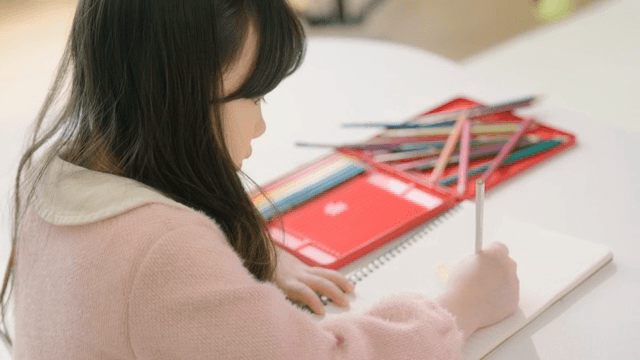 실내에서 색연필로 그림 그리는 아이