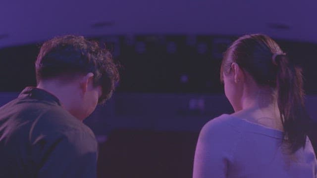 보라색 조명 아래 앉아 있는 연인의 뒷모습