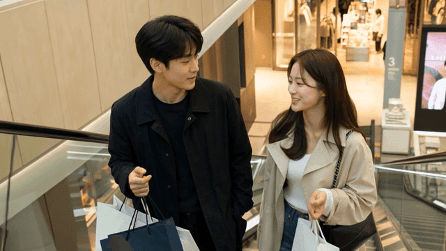 Couple going up escalator with shopping bags at shopping mall
