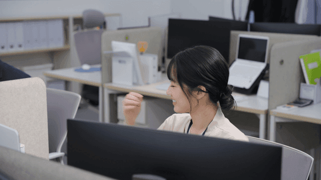 사무실에서 동료와 웃으며 얘기하는 직장인