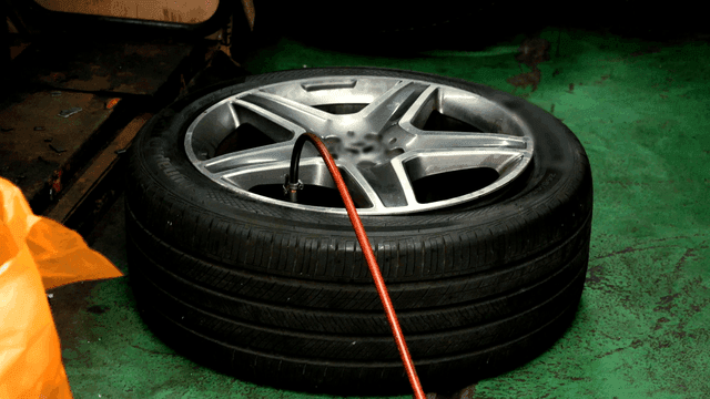 Car tire being inflated in a workshop