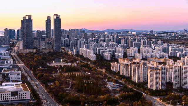 Cityscape with a park transitioning from day to night