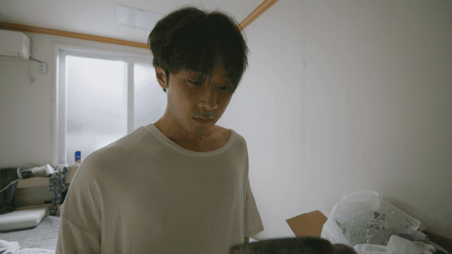 어수선한 방에서 망치를 드는 젊은 남성