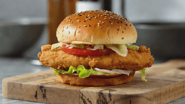 나무 도마 위의 바삭한 치킨 버거