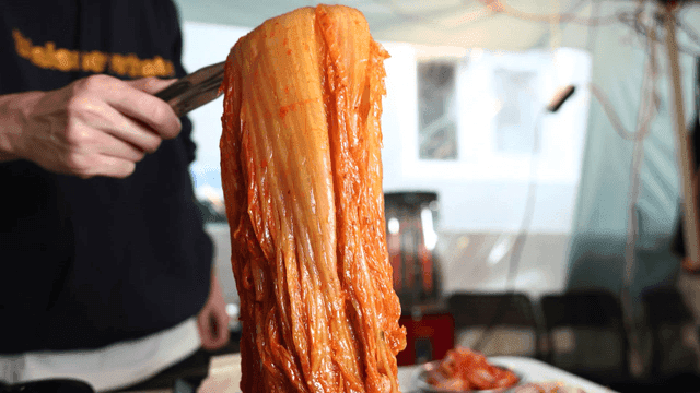 Kimchi stew lifted with tongs