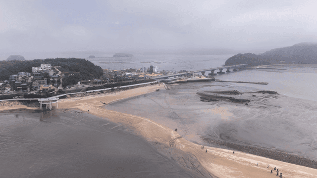 Tidal flat coastal village with sandbar