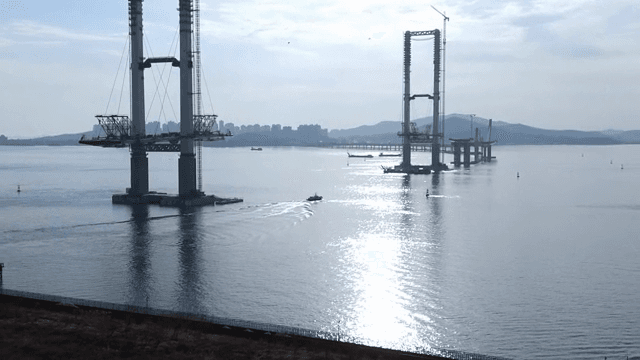 Boat passes by a bridge under construction