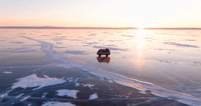 해질녘 얼어붙은 호수 위를 달리는 차량