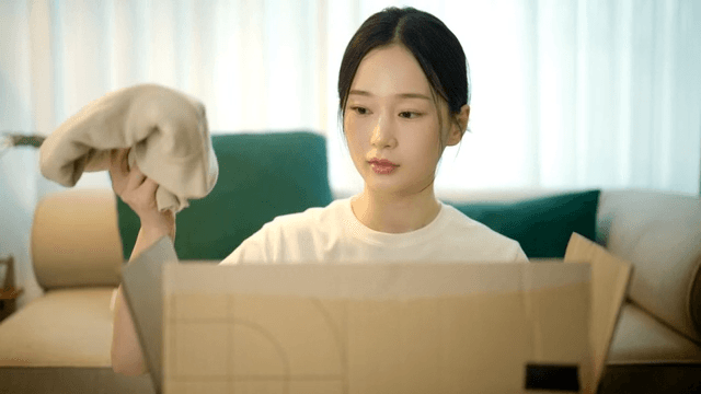 Woman packing clothes into boxes in her cozy living room