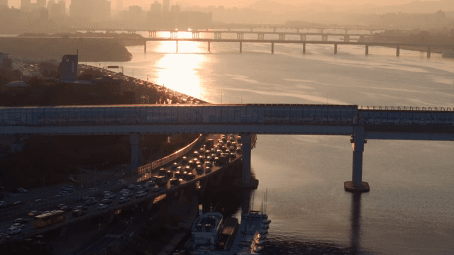 붐비는 도시 다리와 강의 일몰