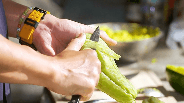 Peeling a green vegetable with a knife