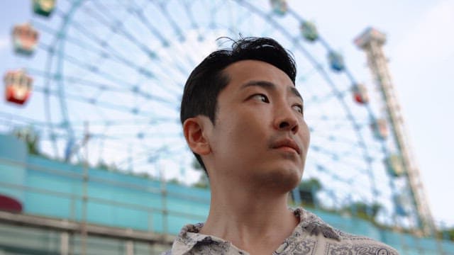 Man standing in front of a ferris wheel