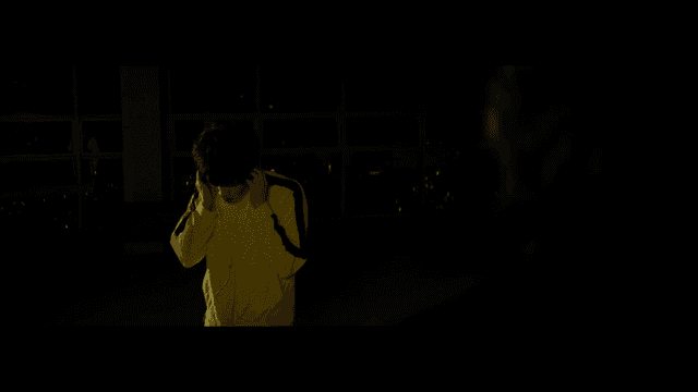 노란색 재킷을 입고 음악을 듣는 사람