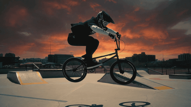 BMX rider performing tricks at sunset