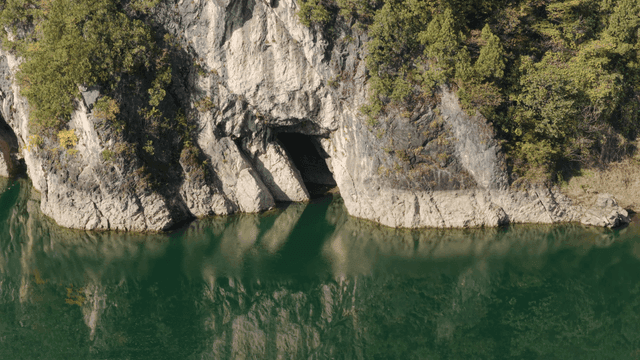 강가에 동굴이 있는 바위 절벽