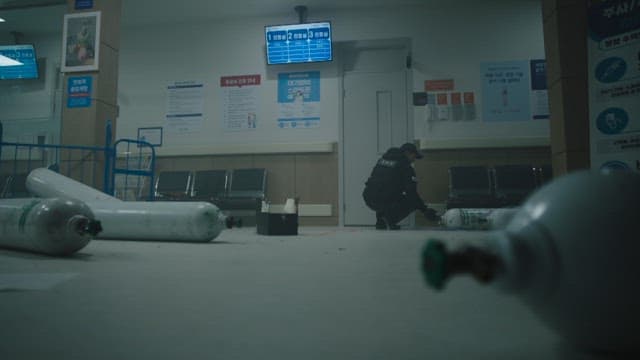 Person examining corridors and doors littered with gas cylinders