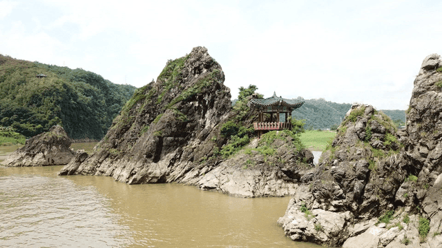Traditional pavilion on rocky cliff by river