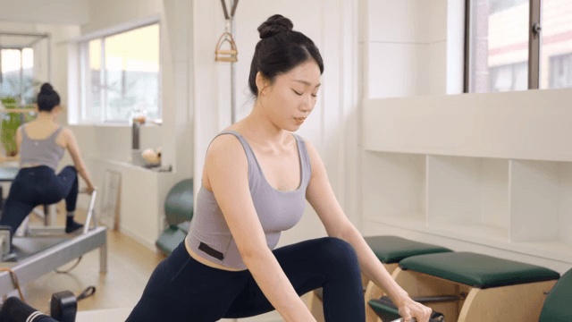 Woman practicing pilates on a reformer