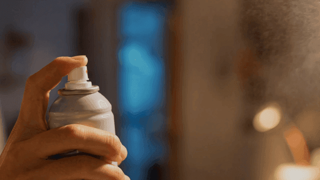 Hand pressing spray can indoors