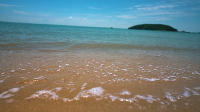 Sandy Beach with Waves Glittering in the Sunlight