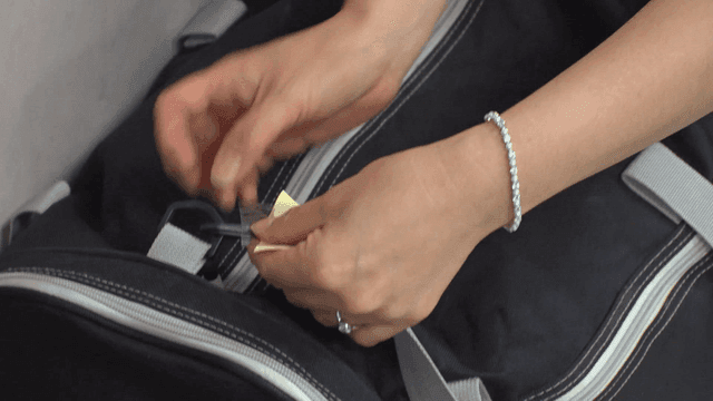 Person attaching note to black bag