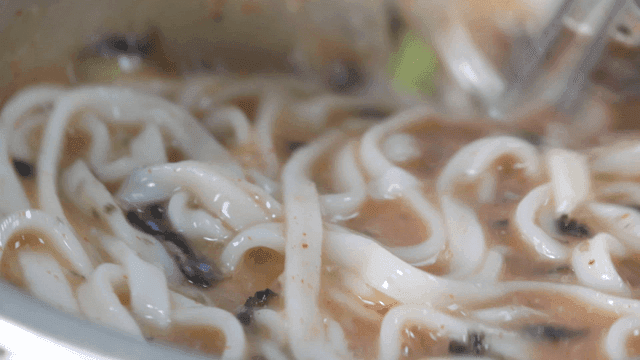 Chicken noodle soup stirred in a pot