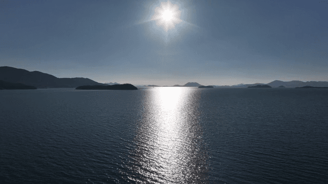 멀리 섬이 보이는 햇빛 비치는 바다