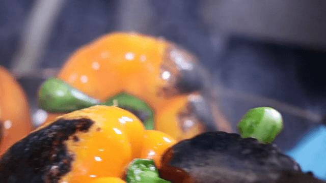 토치로 주황색 파프리카 굽기