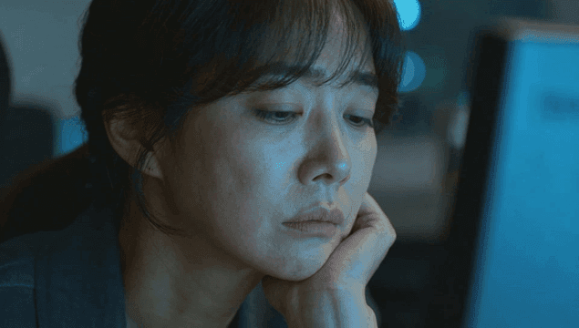 책상에서 늦게까지 일하는 여성