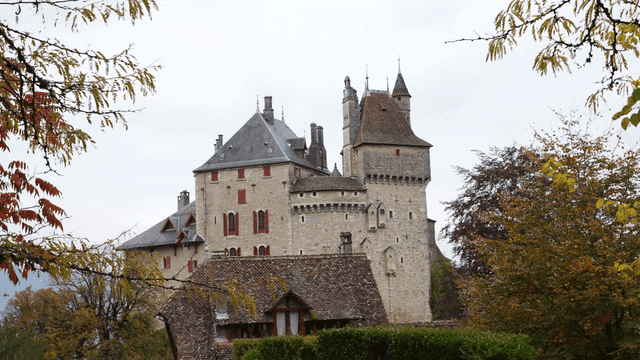 Historic European castle surrounded by autumn foliage