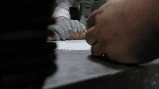 밀가루를 뿌린 표면에서 반죽을 하는 손