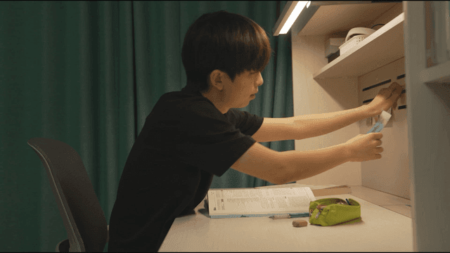 Profile of man studying at desk while looking at note