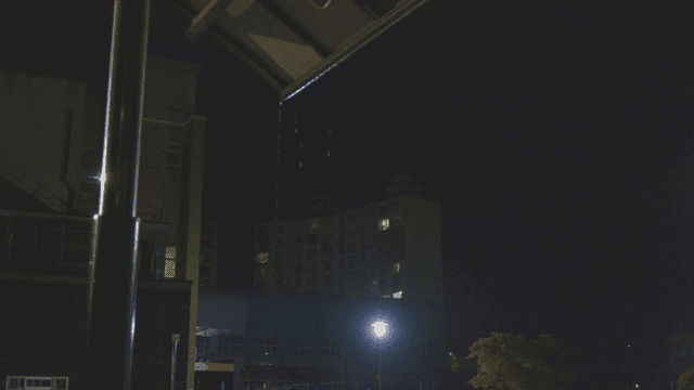 Rain falling over a school with apartment view